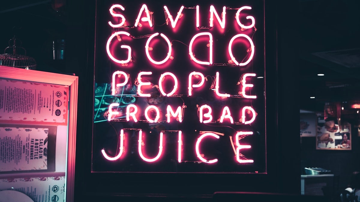 a neon sign that says saving good people from bad juice